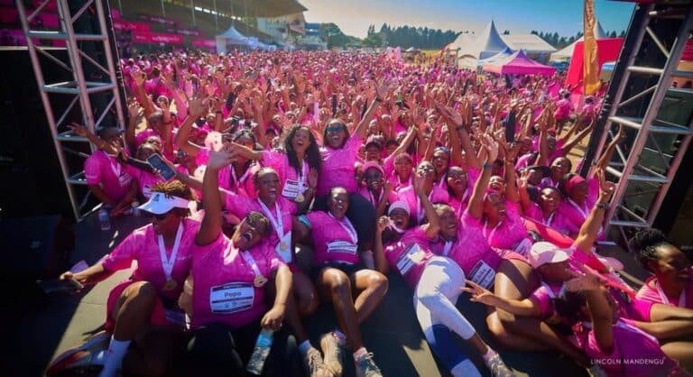Hundreds of women celebrating together at the Her Miles Women's Run, a powerful moment of women's wellness community in Zimbabwe