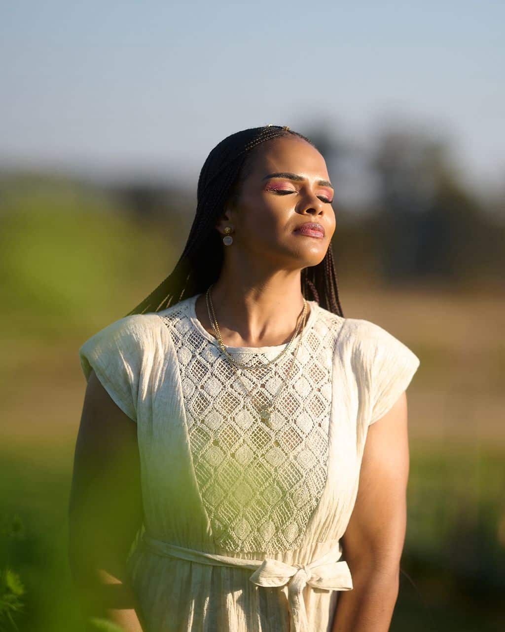 Leya Mnangagwa standing peacefully with eyes closed in golden light, resting in God's presence
